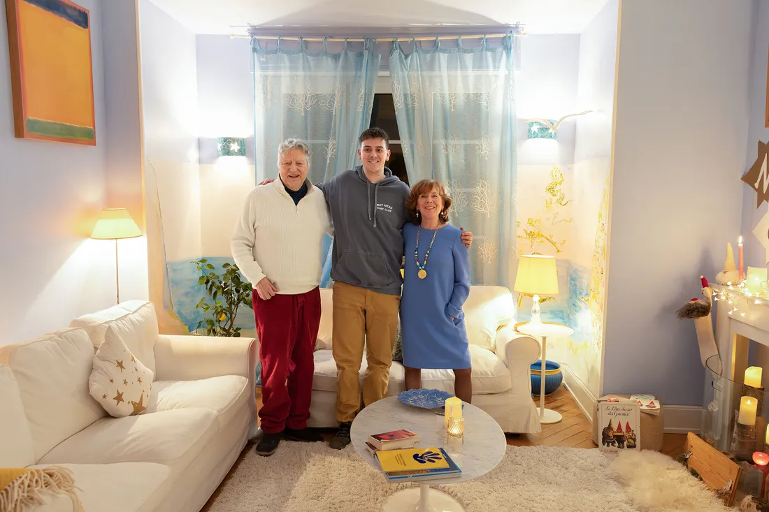 Student and hosts standing in the middle of a living room with their arms around each other