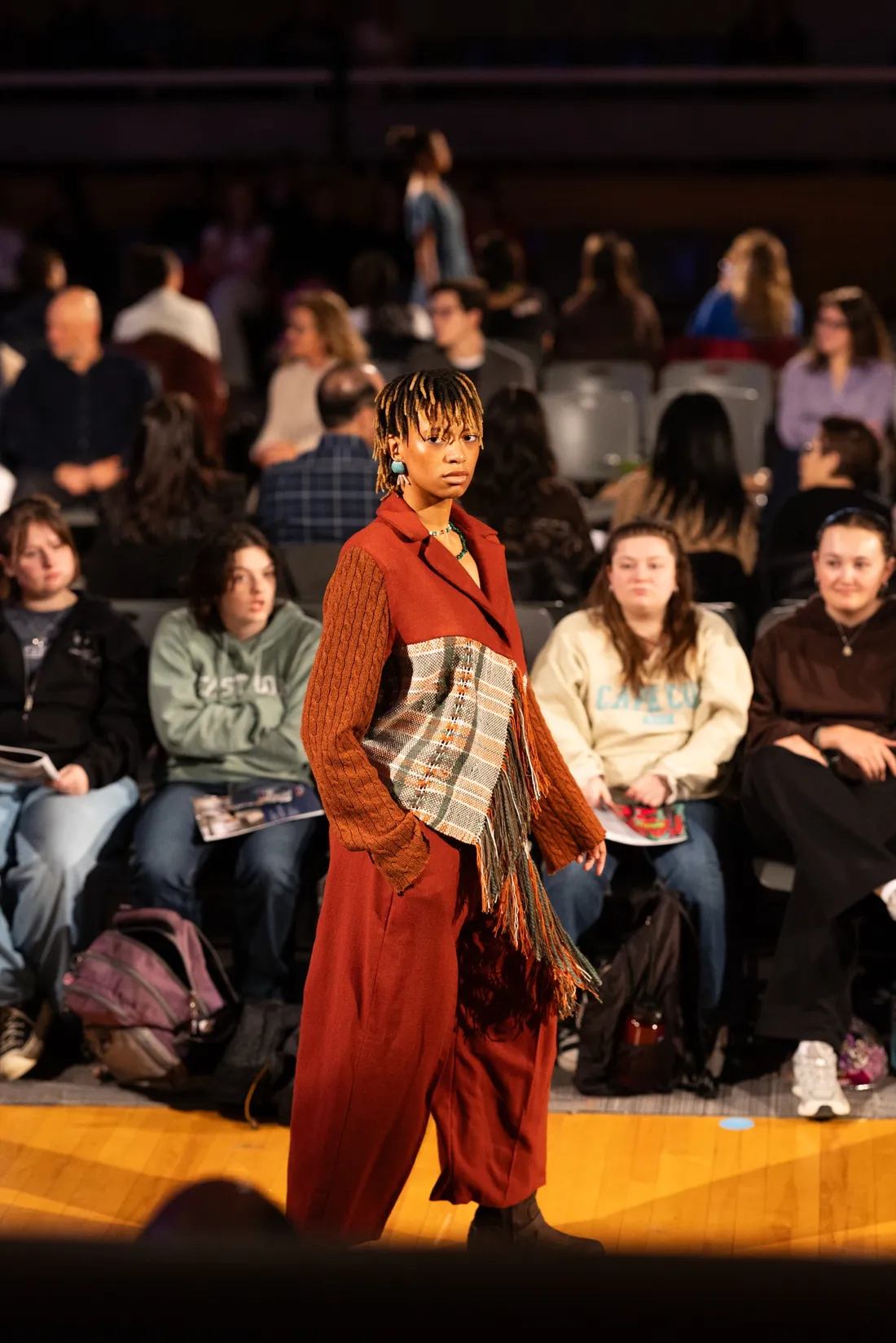 Student modeling on a runway at the College of Visual and Performing Arts' Senior Fashion Show.