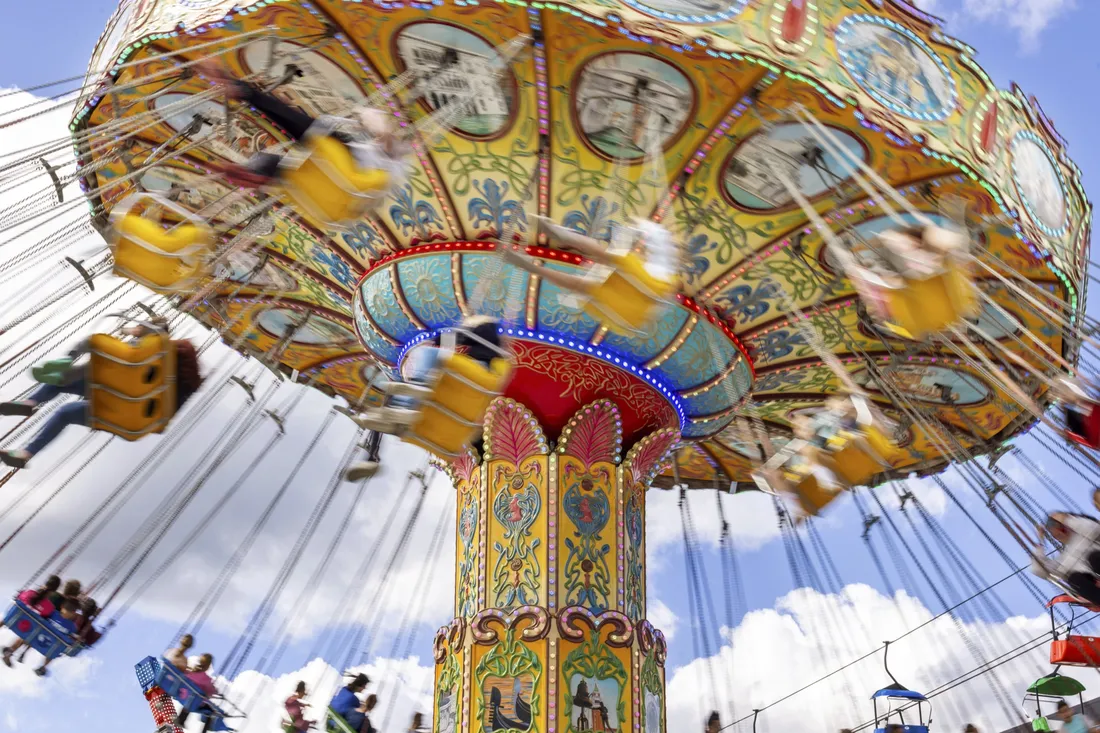 People riding on a spinning fair ride.