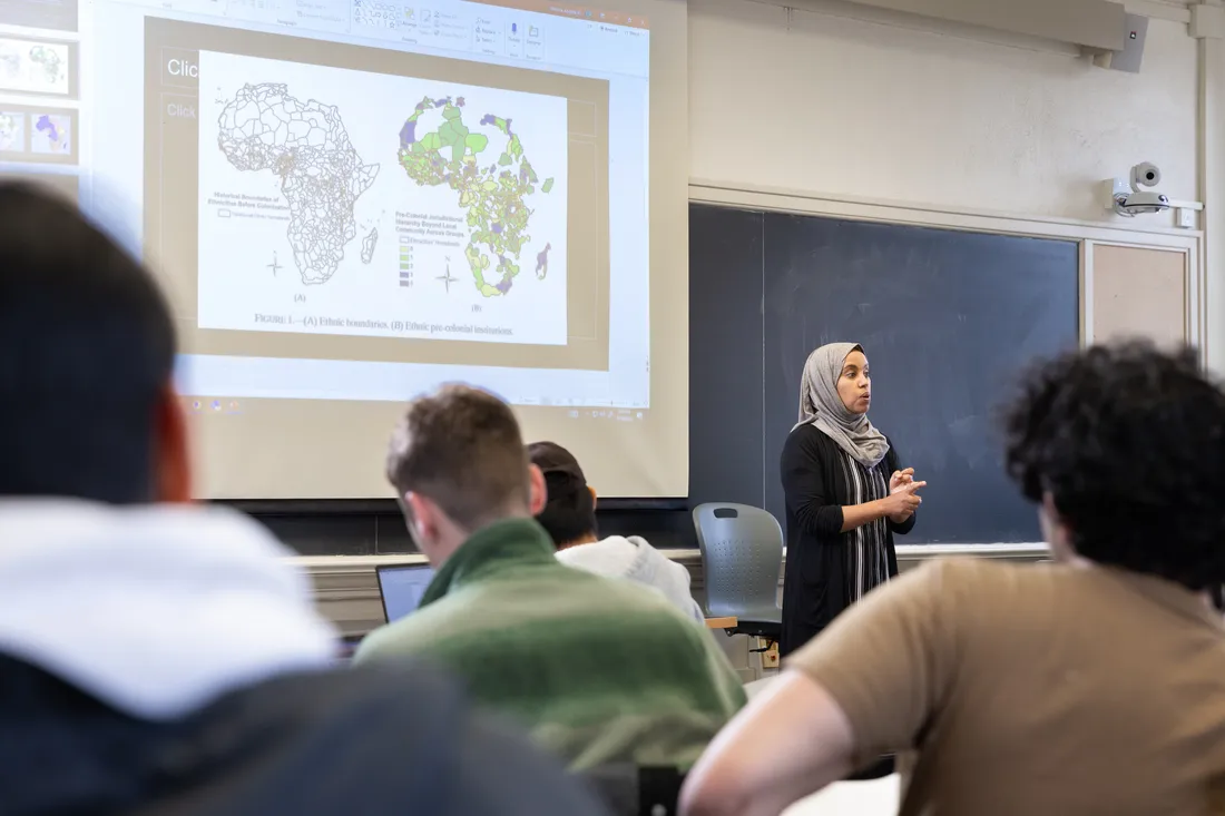 Professor speaking to class of students.