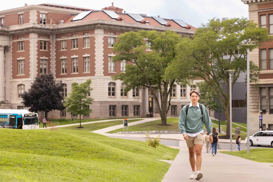 Student walking by ernie davis dorms.