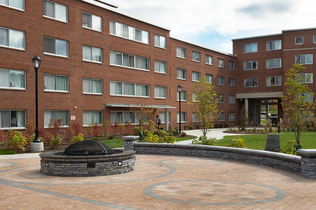 Watson Hall exterior courtyard with a fire pit and nice landscaping.