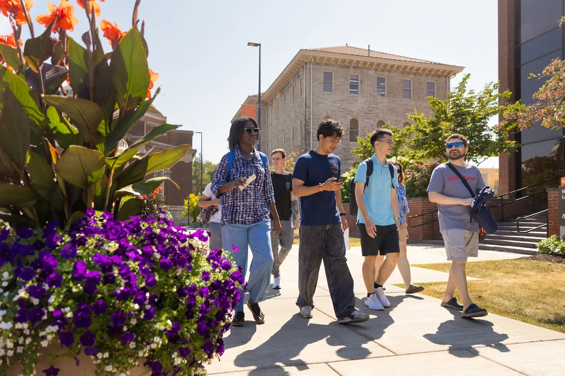 Students walking on campus at syracuse university during the summer.