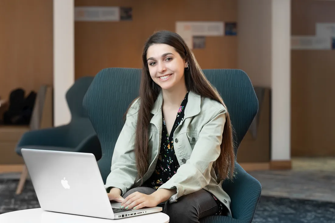 Sofia de la Grana smiling and working on a computer.