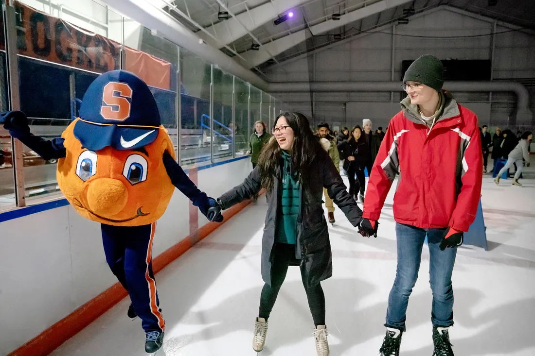 Otto ice skating with two students, all holding hands.