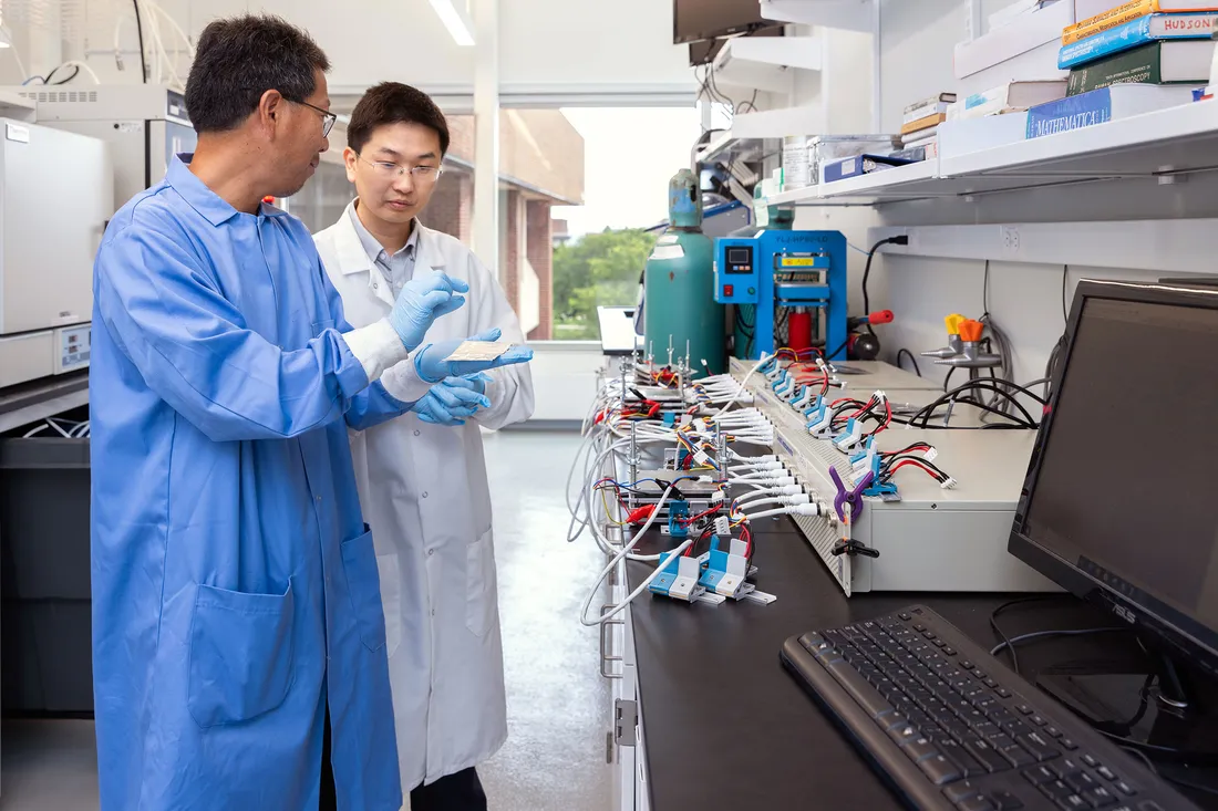 Quinn Qiao working with a student in a lab.