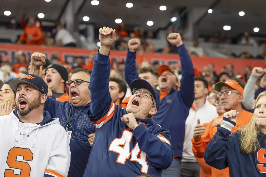 Syracuse University alumni cheering on the Orange during Orange Central homecoming.