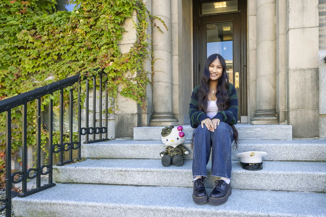 Amy Tran ’27 sitting on the stairs and smiling.