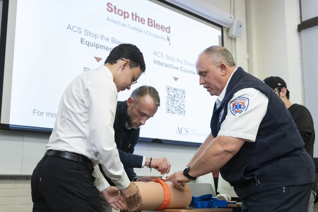 Person teaching CPR class to students.