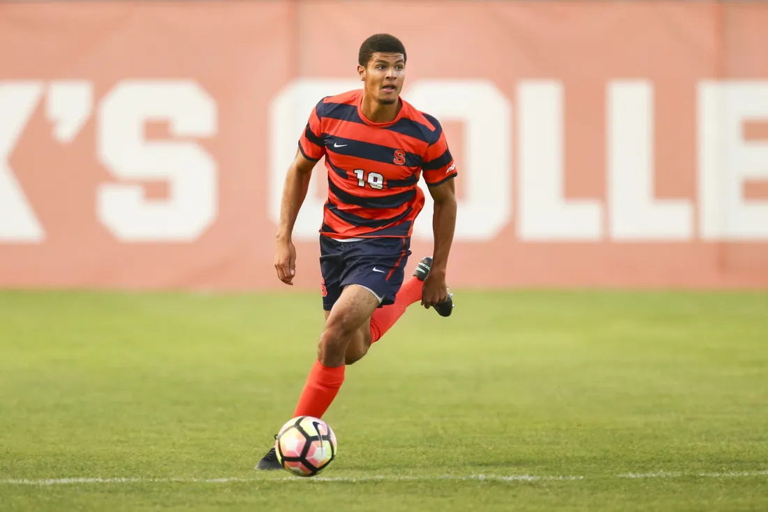 Soccer athlete Miles Robinson standing on a field during a game.