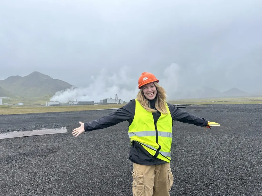Syracuse University student posing in front of the Hellisheidi Geothermal Power Plant in Iceland.