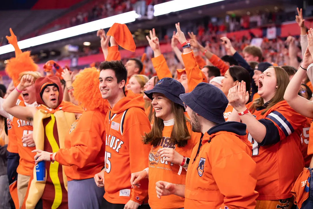 Group of sports fans in a stadium cheering.