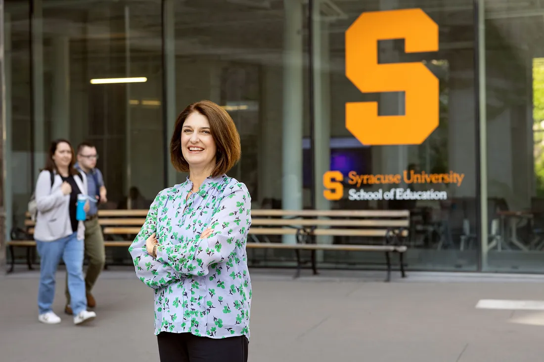 Kelly Chandler-Olcott stands in front of the School of Education.