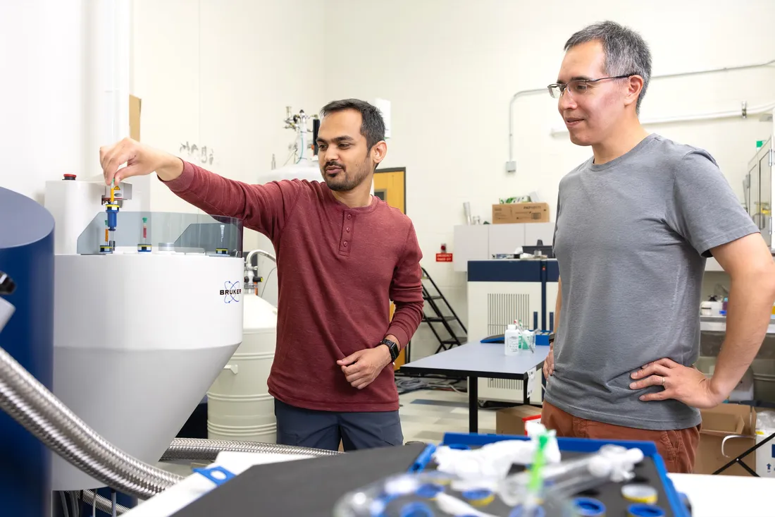 Professor Carlos Castañeda working with another researcher in a lab.