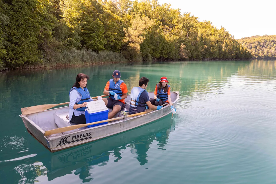 Group of students in a boat sample water from Green Lakes