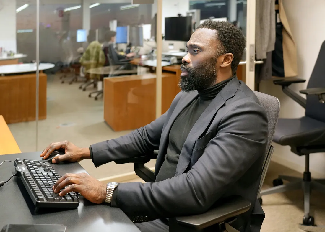 Person sitting at desk typing on computer.