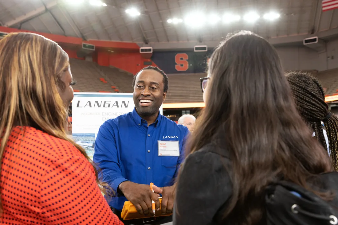 Jared Green speaking with three students.