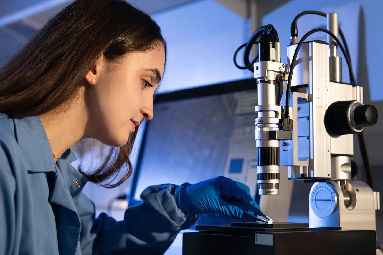 Person preparing a microscope to do research in a lab.
