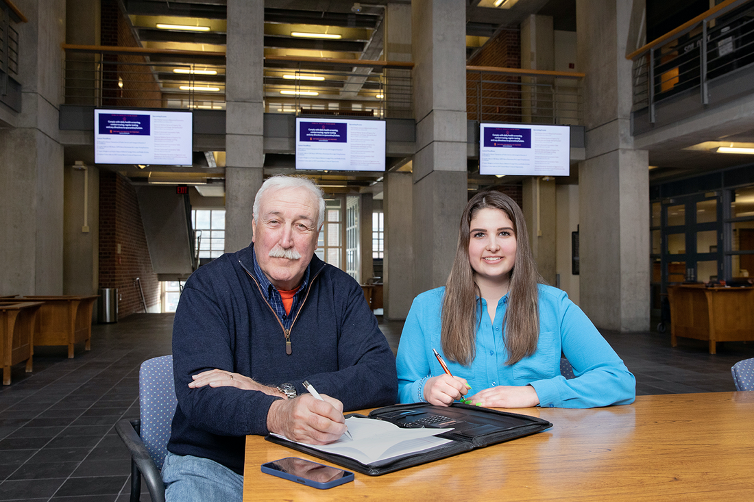 Taylor Grosso and Professor Sean O'Keefe smile for the camera inside Maxwell Hall.