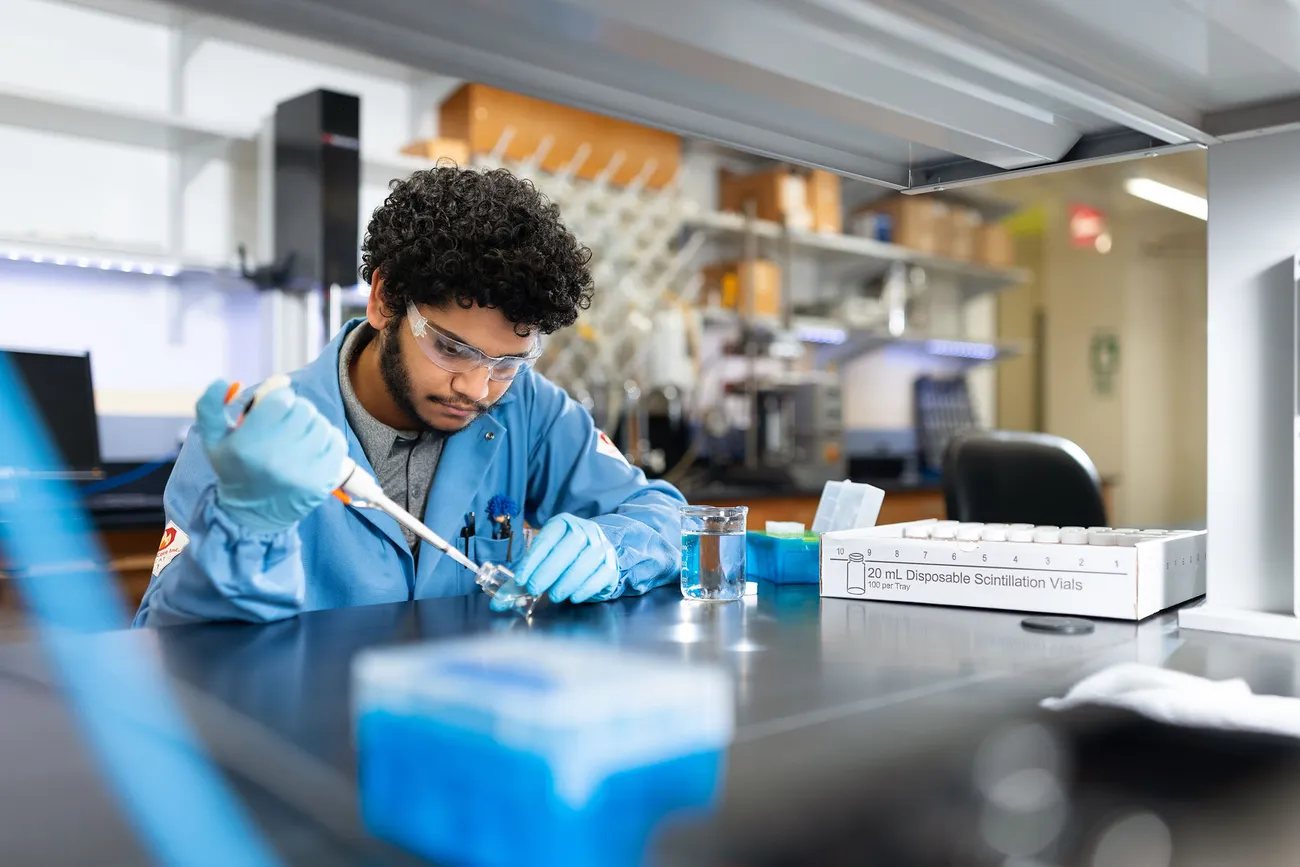 Student working in a chem lab.