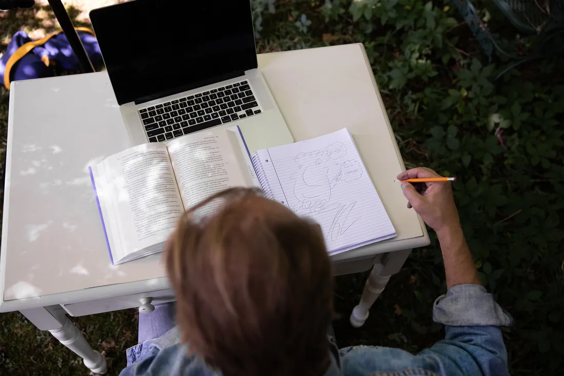 George Saunders sitting outside writing.