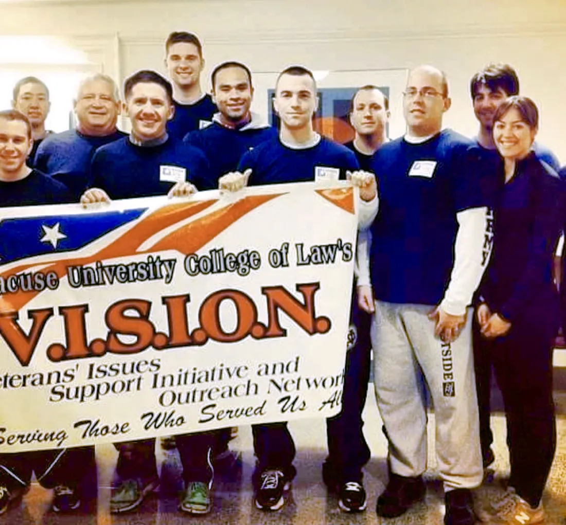 Veterans standing together taking a picture holding a sign for the Veterans Issues, Support Initiative and Outreach Network.
