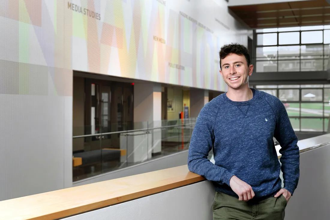 Student in the halls of Newhouse building.