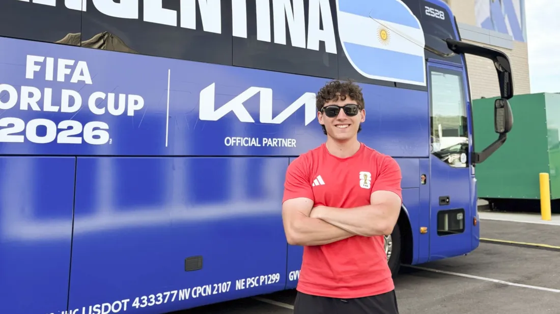 Alumnus Jake Cohen standing in front of a bus.