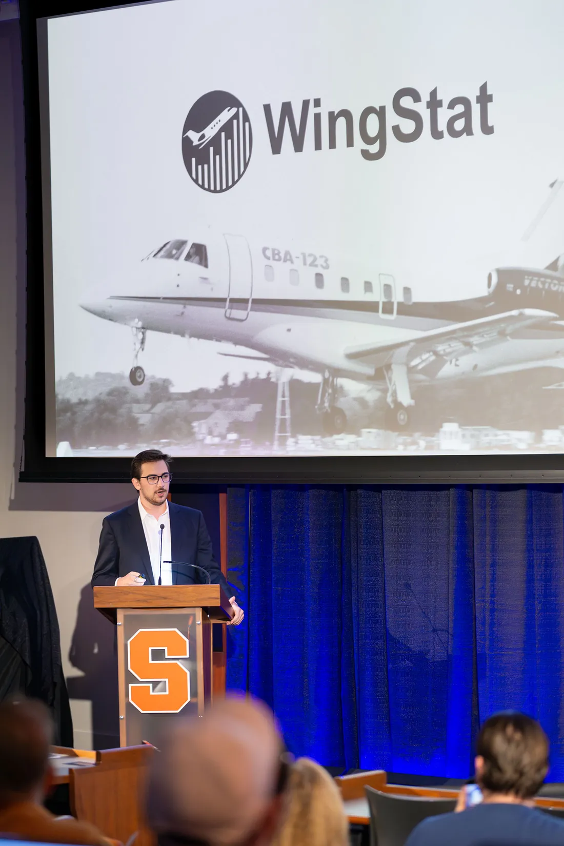 Person giving a presentation while standing at a podium.