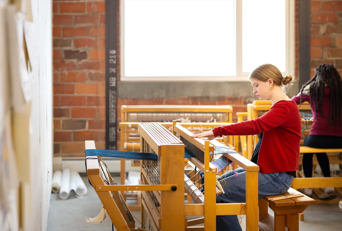 Jane Moss ’29 working on a loom to create a textile pattern.