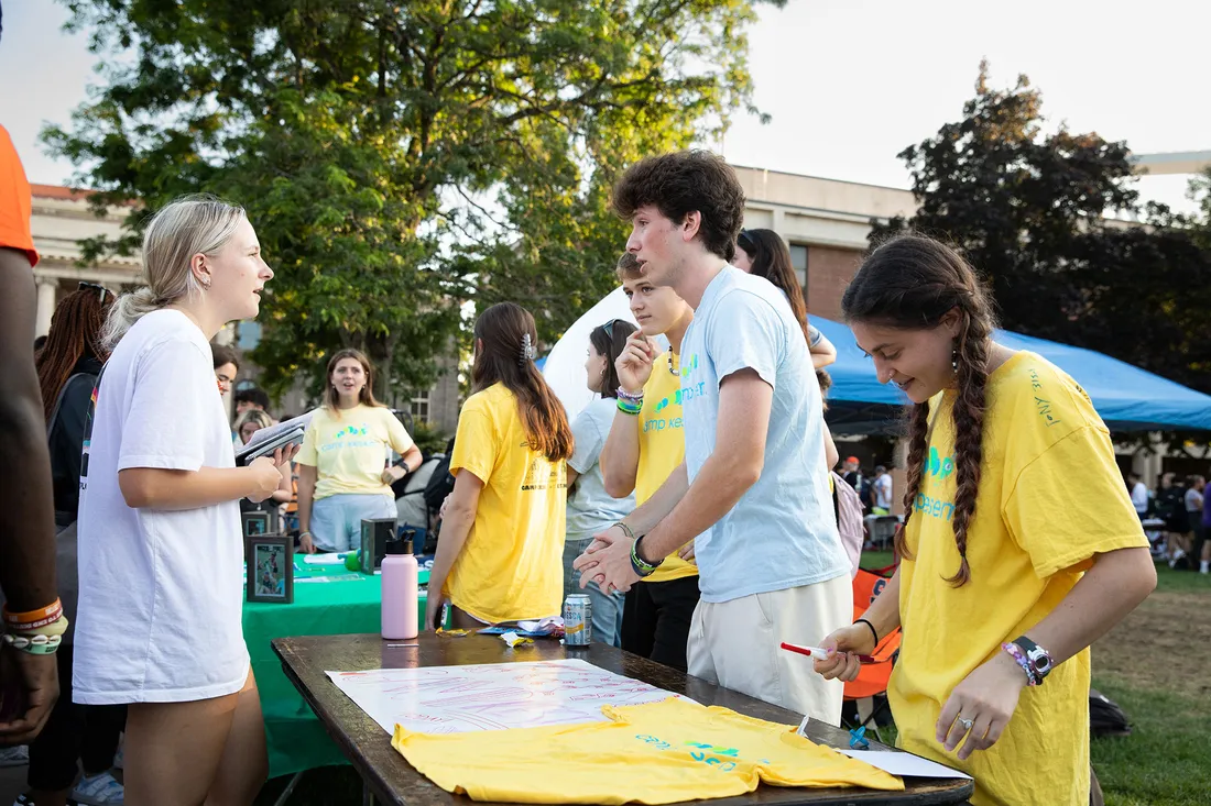 Students around table at involvement fair.