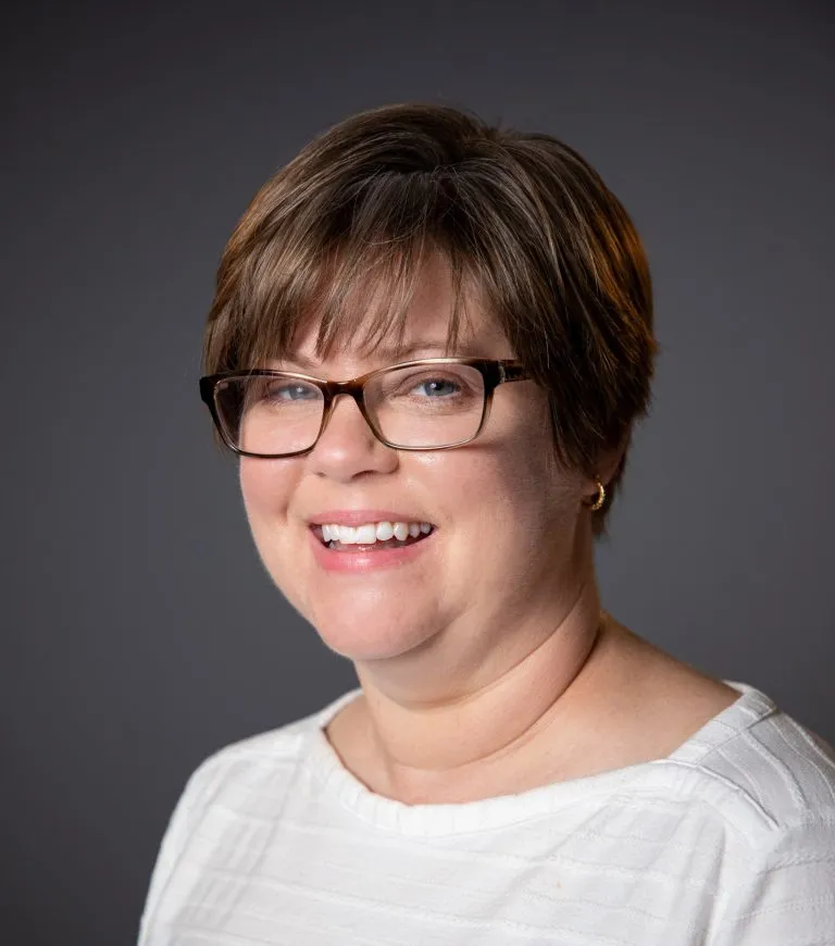 Jennifer Erzen smiling with a white shirt.