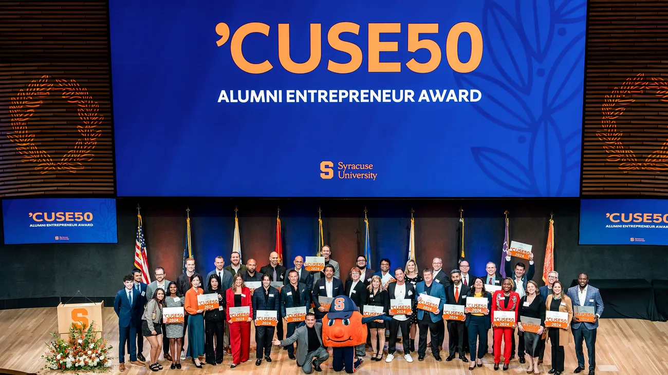 Group of people holding awards on a stage.