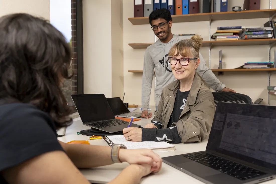 Professor at Syracuse University working with students in her office.