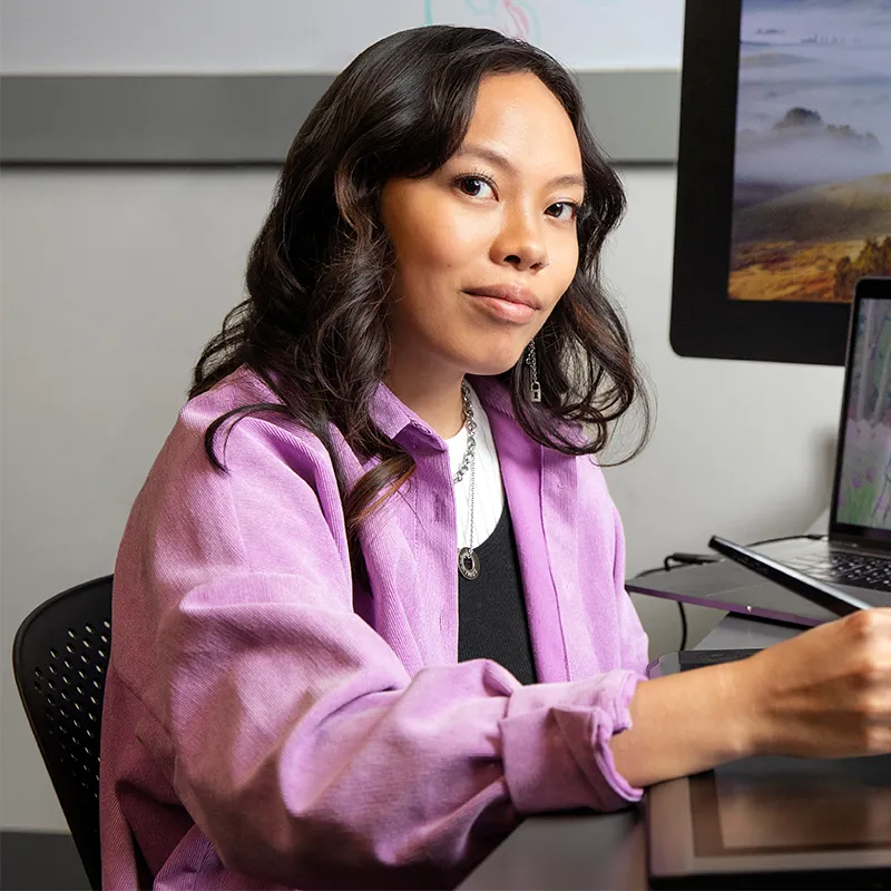 Alyssa Chang sits at computer editing video.