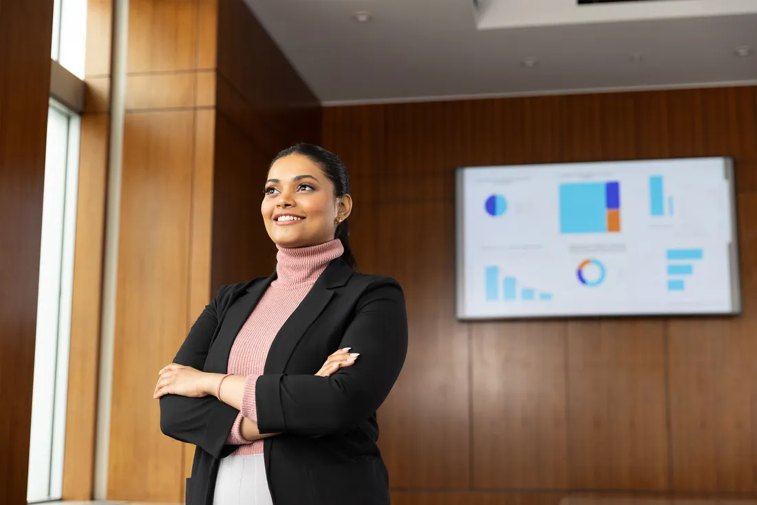 Portrait of Sanyukta Gharat standing and smiling with arms crossed.