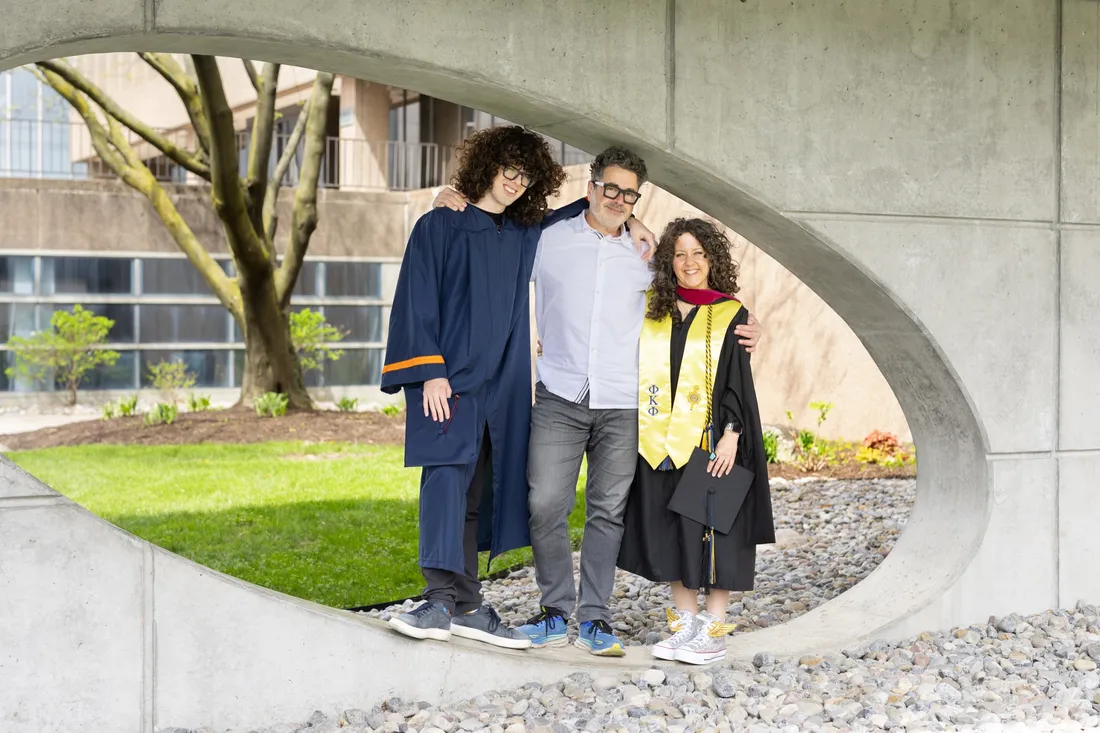 Professor Ken Rogers standing with his son Rio Harper '26 and wife Dara Harper G'26.