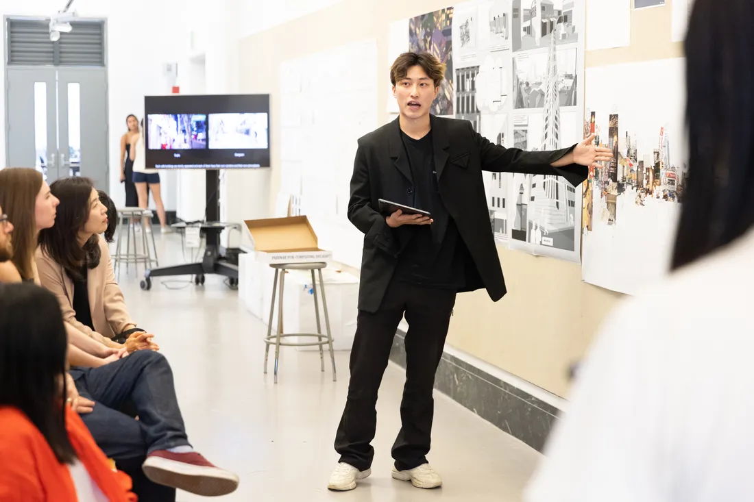 Student presents architecture mockups in presentation.