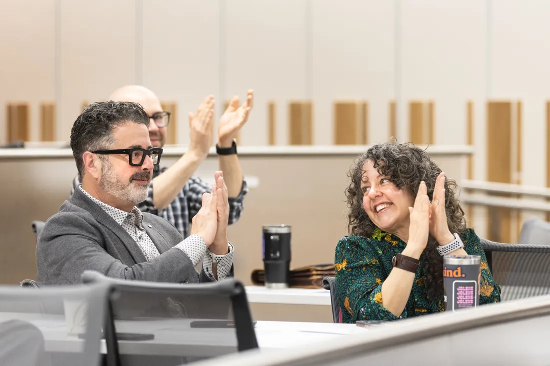 Ken Harper and Dara Harper G'26 clapping for son Rio Harper at his Newhouse Impact Symposium presentation.