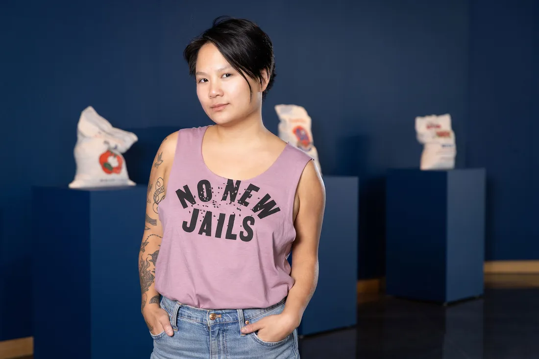 Portrait of Stephanie Shih wearing a tanktop that says "No New Jails" on it.