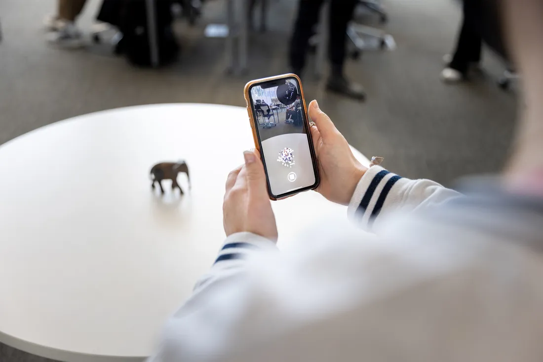 A student scans an object using the Trnio Plus 3D capture app.