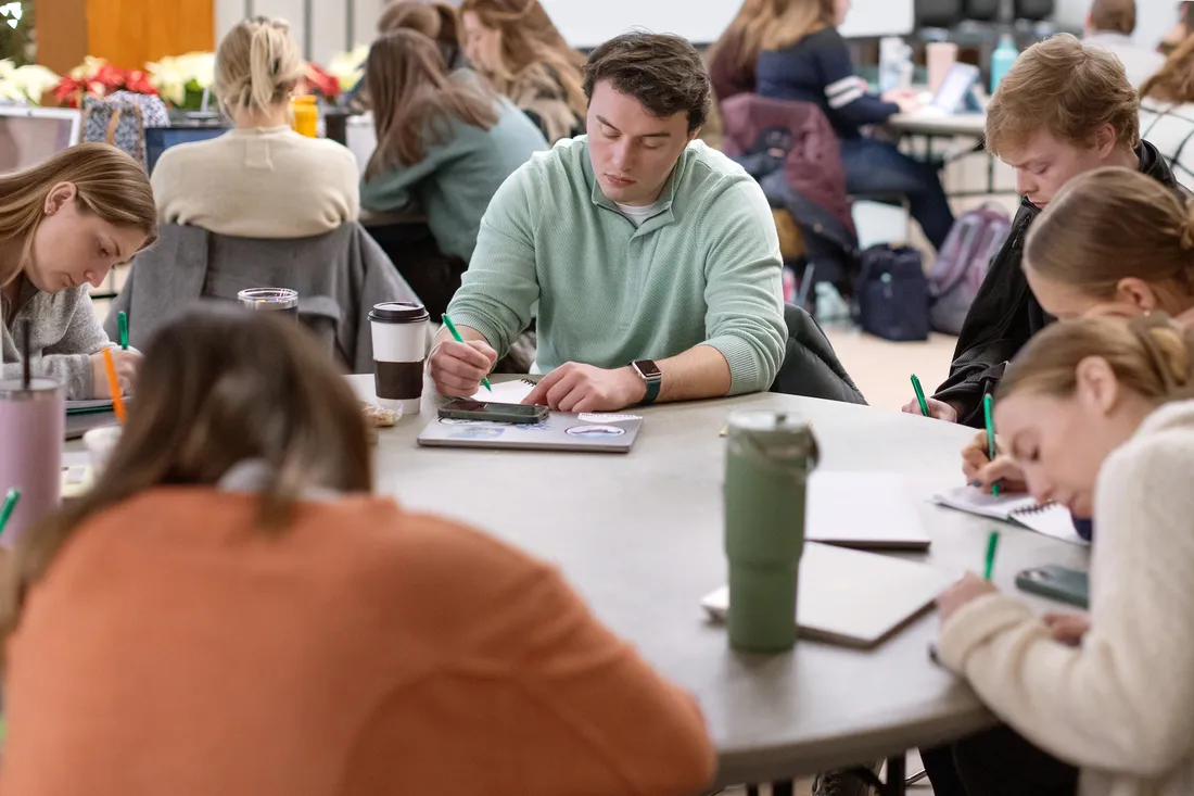 Students sitting at a table at a writing workshop.