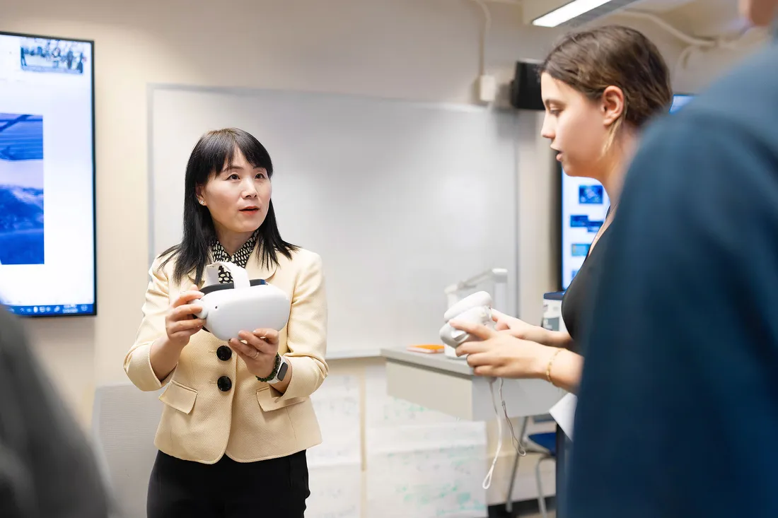 Teacher showing students a virtual reality headset.