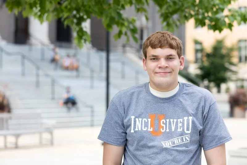 A portrait of InclusiveU student Samuel Clark in front of the steps of Carnegie Library.