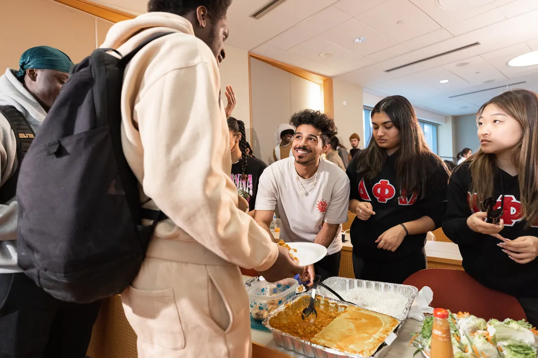 Students getting food from catering trays.