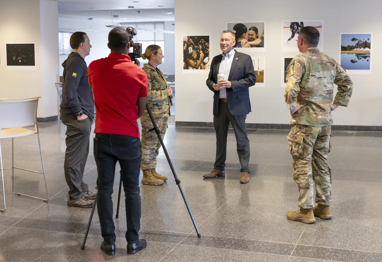 Chancellor Haynie speaking with military students in front of a camera for an interview.