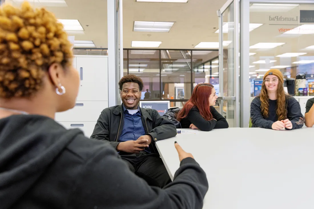 Students sitting at table talking.