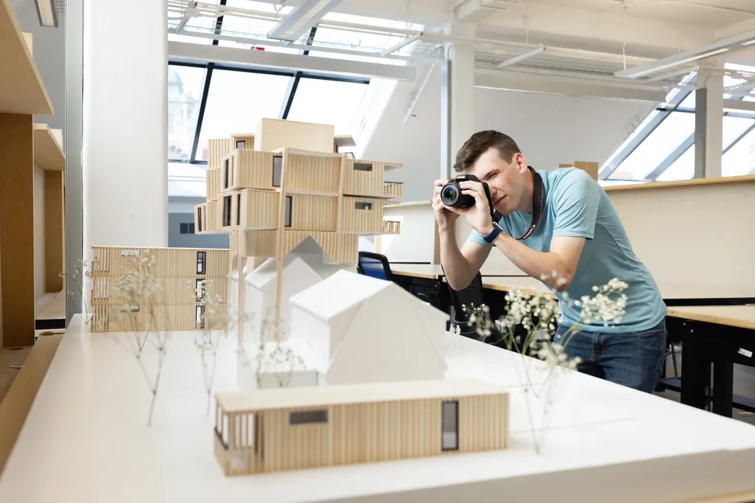Architecture student taking a picture of project.