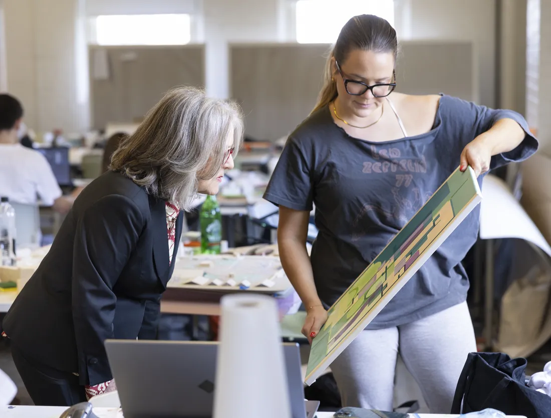 Diana Wege '76 looking at a student's painting.