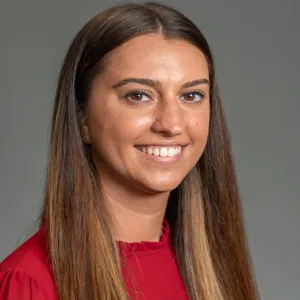 Danielle DiMaria smiling in a red shirt.